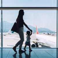 silhouette of joyful young asian mother holding hands of cute little daughter looking at airplane through window at the airport while waiting for departure - travel stockfoto's en -beelden