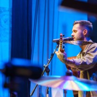 singer playing guitar and singing on stage during a concert - concert photos et images de collection