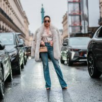 Sira Pevida wears white oversized sherpa aviator jacket, light blue washed skinny denim jean pants, shiny black pointed toe knee high heels, dark...
