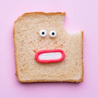 sliced bread with faces on pink background - junk food stock pictures, royalty-free photos & images