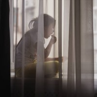 small girl in white t-shirt and yellow leggings sits on window sill, indulging in quiet snack - junk food stock pictures, royalty-free photos & images
