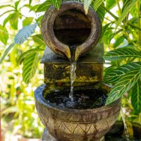 small stone water fountain in garden with plant - garden decoration stock pictures, royalty-free photos & images