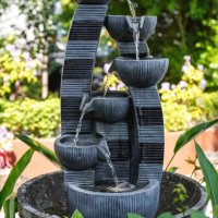 small tiered water fountain in lush green garden - garden decoration stock pictures, royalty-free photos & images