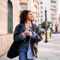 smiley afro woman using a mobile walking in the street - fashion stock pictures, royalty-free photos & images