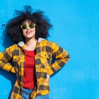smiling american-african woman standing on a blue background - fashion stock pictures, royalty-free photos & images