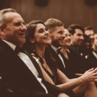 smiling audience sitting in the theater - concert stock pictures, royalty-free photos & images