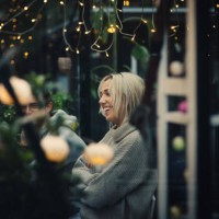 smiling blond young woman sitting amidst friends at dining table in back yard during garden party - garden decoration stock pictures, royalty-free photos & images