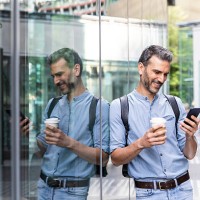 smiling businessman looking at the smartphone in the city, berlin, germany - junk food stock pictures, royalty-free photos & images