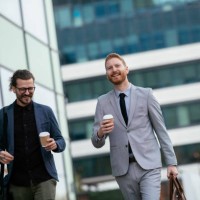 smiling businessman walking with coffee cups stock photo - junk food stock pictures, royalty-free photos & images