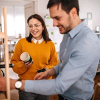 smiling colleagues making coffee in cafeteria at office - coffee stockfoto's en -beelden