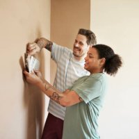 smiling couple choosing paint color for home - home decoration stock pictures, royalty-free photos & images