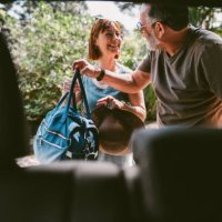 smiling couple packing bags in their car after a weekend away - travel stock pictures, royalty-free photos & images