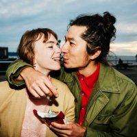 smiling couple sharing piece of chocolate while on date - food stock pictures, royalty-free photos & images