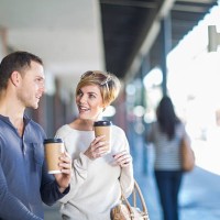 smiling couple with coffees to go - junk food stock pictures, royalty-free photos & images