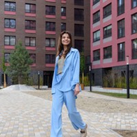 smiling fashionable woman in a blue suit posing in a new collection of summer clothes on a city street - fashion stock pictures, royalty-free photos & images