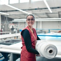 smiling female textile worker carrying heavy rolled materials for printing roller machine - fashion stock pictures, royalty-free photos & images