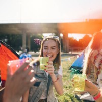 smiling friends enjoying drinks in music concert during summer - concert stock pictures, royalty-free photos & images