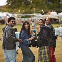 smiling friends with arms around walking at park - concert stock pictures, royalty-free photos & images