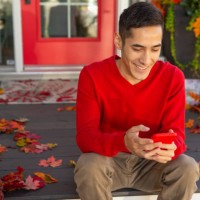 smiling man texting on front autumn porch - garden decoration stock pictures, royalty-free photos & images