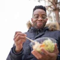 smiling man with eyeglasses having salad during winter - junk food stock pictures, royalty-free photos & images
