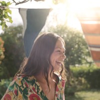 smiling mid adult woman looking away while standing in backyard - garden decoration stock pictures, royalty-free photos & images