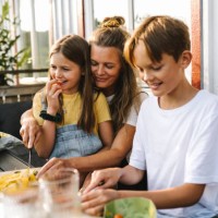 smiling mother cutting vegetable on table in balcony - food stock pictures, royalty-free photos & images