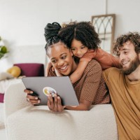 smiling parents and daughter at home watching online movie together - home decoration stock pictures, royalty-free photos & images