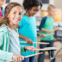 smiling schoolgirl plays drums during percussion class - concert stock pictures, royalty-free photos & images