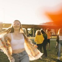 smiling woman dancing with friends in background at event on sunny day - concert stock pictures, royalty-free photos & images