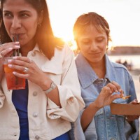 smiling woman drinking juice by friends - junk food stock pictures, royalty-free photos & images