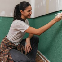 smiling woman finishing wall painting task - home decoration stock pictures, royalty-free photos & images