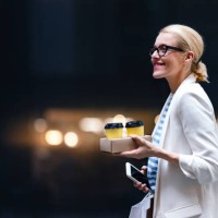 smiling woman holding two cups of coffee, mobile phone and shopping bags outdoors - junk food stock pictures, royalty-free photos & images