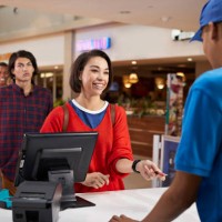 smiling woman paying for movie tickets - junk food stock pictures, royalty-free photos & images