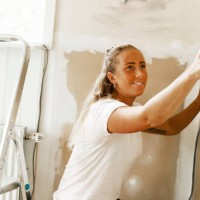 smiling woman sanding wall while renovating home - home decoration stock pictures, royalty-free photos & images