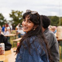 smiling woman wearing jacket sitting with friends - concert stock pictures, royalty-free photos & images