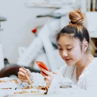 smiling young asian woman enjoying chinese food in bedroom - junk food stock pictures, royalty-free photos & images