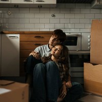 smiling young couple day dreaming while sitting amidst boxes in new home - home decoration stock pictures, royalty-free photos & images