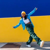 smiling young dancer dancing with arms outstretched on footpath - fashion stock pictures, royalty-free photos & images