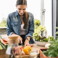 smiling young woman chopping vegetables on cutting board in yard - food stock pictures, royalty-free photos & images