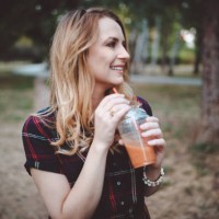 smiling young woman drinking smoothie in the public park - junk food stock pictures, royalty-free photos & images