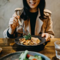 smiling young woman enjoying dinner date with friends in a restaurant - food stock pictures, royalty-free photos & images