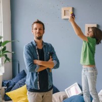 son blowing confetti over proud father holding hammer at home - home decoration stock pictures, royalty-free photos & images