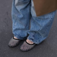 Sonia Lyson is seen wearing a beige long coat from Sezane, wide jeans from Zara and rhinestones-covered black net ballet flats from Zara on September...