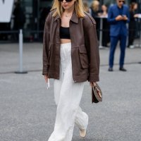 Sonia Lyson wears shoes Tabitha Simmons, white pants Zara, brown leather jacket Ducie London, Louis Vuitton round bag, YSL sunglasses outside Lueder...