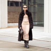 Sophia Geiss wears beige sheer dress, dark brown fur coat, brown leather boots, brown pouch bag and sunglasses outside the Herskind fashion show...