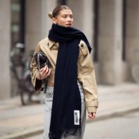 Sophia Geiss wears grey jeans, beige crop trench coat, black soft leather pouch bag and long black scarf during the Copenhagen Fashion Week...