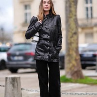 Sophia Roe wears a black shiny glitter jacket, a black and white striped bag, black flared corduroy pants , outside Chanel, during the Womenswear...
