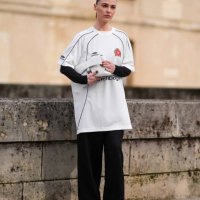 Sophia Roe wears a white Balenciaga top designed as a soccer / football top, black wide-leg pants, black leather high heels shoes, a white Balenciaga...