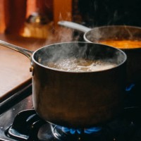 soup boiling in cooking pans on gas burning stove - food stock pictures, royalty-free photos & images