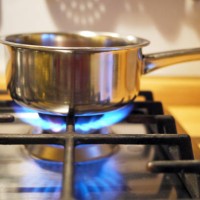 stainless steel pan on gas stove - food stockfoto's en -beelden